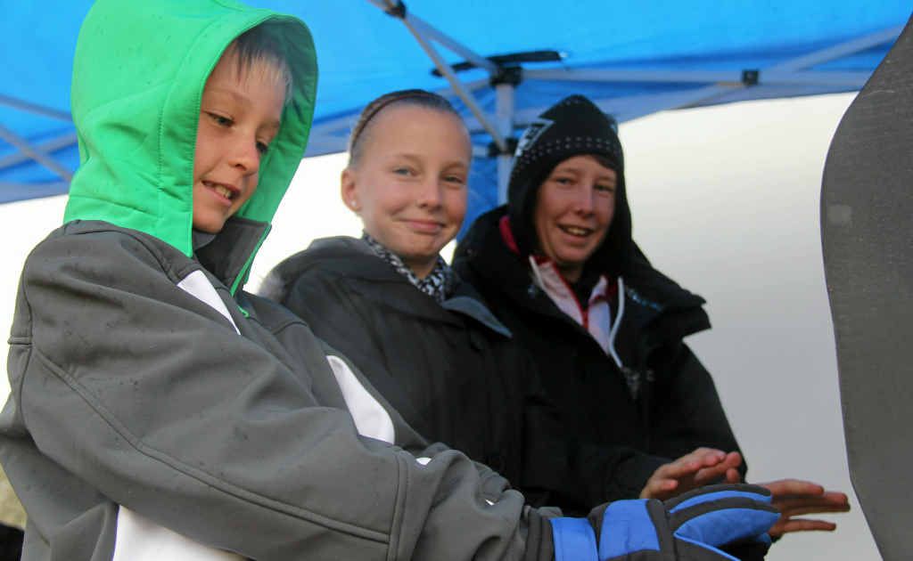 Diarmin, Anniston and Carter Chappell from Maryborough warmed themselves near the barbecue at the hockey fields yesterday.